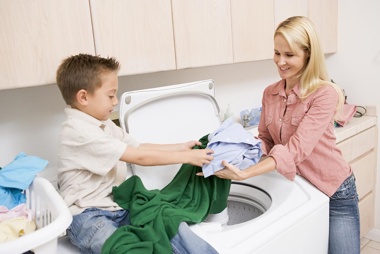 son doing laundry with mother
